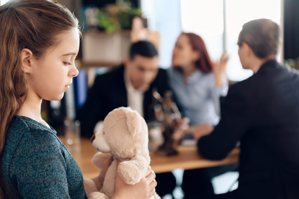 sad looking girl with parents arguing over child arrangement order